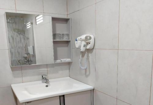 a bathroom with a phone on the wall next to a sink at Nusantara Hotel Sembalun in Sembalun Lawang