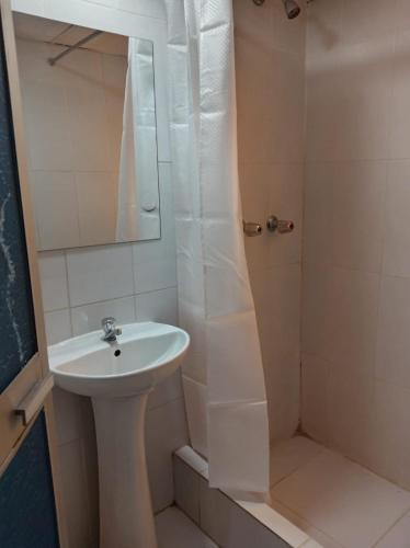 a bathroom with a sink and a shower with a mirror at Hosp Sophie in Cusco