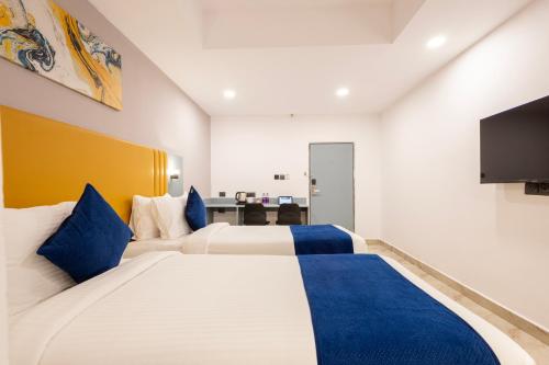a hotel room with two beds and a flat screen tv at beestay hotels Near US Consulate in Hyderabad