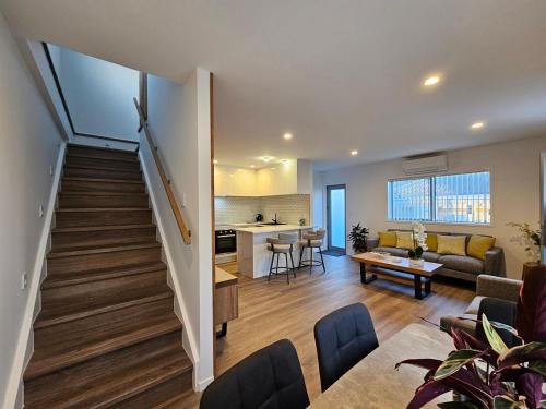 un soggiorno con una scala che conduce a una cucina di New spacious townhouse ad Auckland