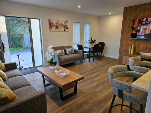 un soggiorno con un divano e un tavolo di New spacious townhouse ad Auckland