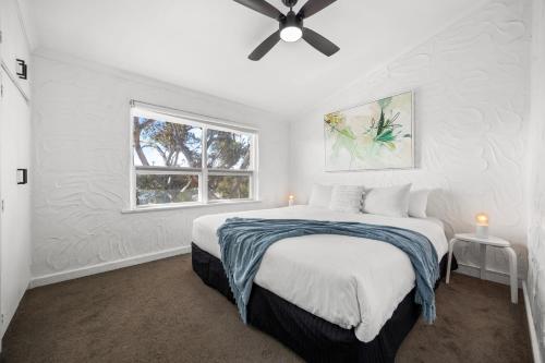 Un dormitorio blanco con una cama y una ventana. en Ivy's at Glenelg Central - A Cosy Family Stay, en Glenelg