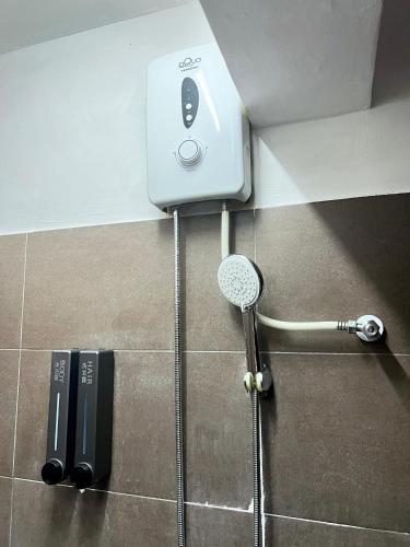 a shower with a microphone in a bathroom at Quee Hotel in George Town