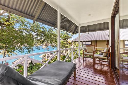 a room with a balcony with a view of the water at Iririki Island Resort & Spa in Port Vila