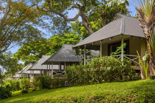 a house with a gray roof on a green lawn at Iririki Island Resort & Spa in Port Vila