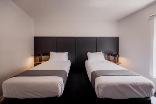 two beds sitting next to each other in a room at Shipwrights Arms Hotel in Hobart
