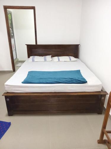 a bedroom with a bed with a wooden frame at Nilanthi Guest House in Welimada