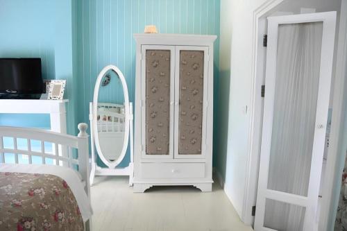 a bedroom with a white cabinet and a mirror at Baan Hmon-Oon in Chiang Mai