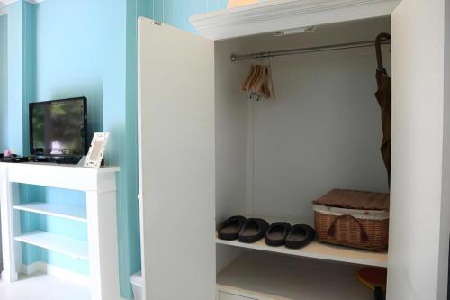 a walk in closet with a white cabinet and shoes at Baan Hmon-Oon in Chiang Mai