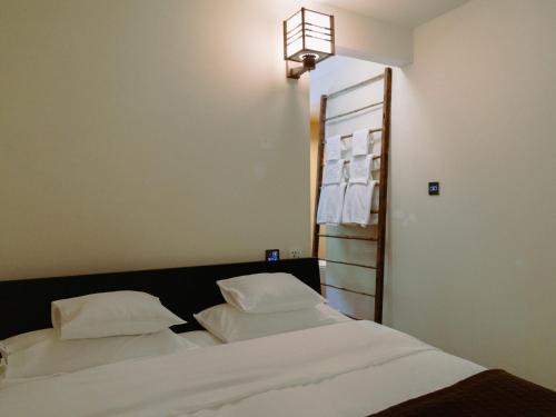 a bedroom with two white pillows on a bed at LA TERRA narai in Shiojiri