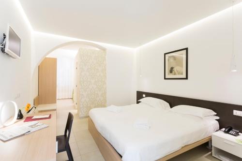 a hotel room with a bed and a desk at Hotel Novecento in Scicli