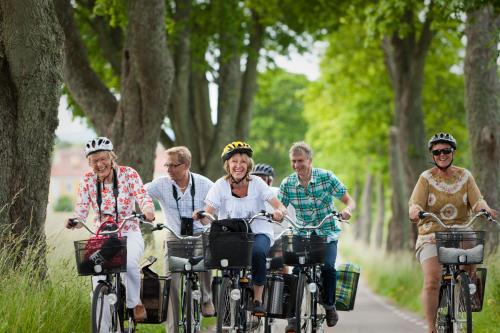 um grupo de pessoas andando de bicicleta por uma estrada em Ringsjöstrand Hotel em Hörby