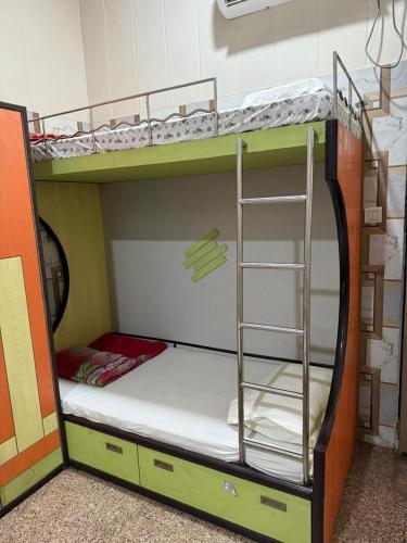 a bunk bed with a ladder in a room at Kalindi Blessings Deluxe Guest House in Mathura