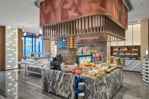 a buffet in a restaurant with food on a counter at voco Xitang by IHG in Jiaxing