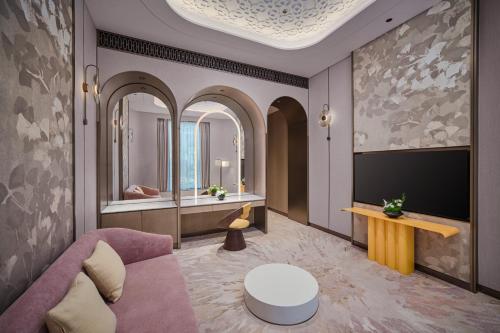 a living room with a couch and a mirror at voco Xitang by IHG in Jiaxing