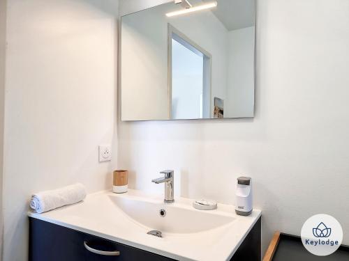 a bathroom with a sink and a mirror at Villa Clokassya - 60m2 avec piscine - Saint-Pierre in Saint-Pierre