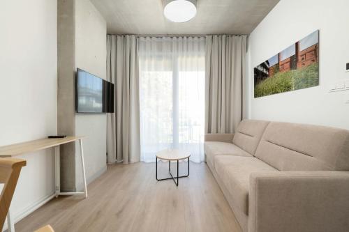 a living room with a couch and a table at Luxury Apartments with Parking and Air Conditioning near Wrocław City Center by Renters Prestige in Wrocław