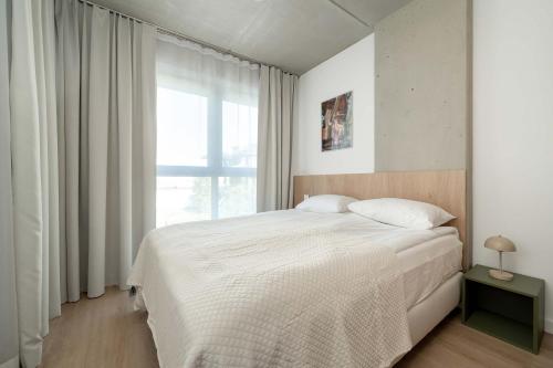 a bedroom with a white bed and a window at Luxury Apartments with Parking and Air Conditioning near Wrocław City Center by Renters Prestige in Wrocław