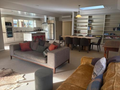 a living room with a couch and a table at Alpine Rose Retreat in Arrowtown