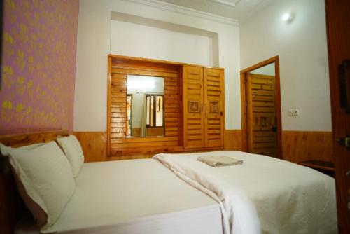 a bedroom with a white bed and a mirror at Thakur ji haveli in Jaisalmer