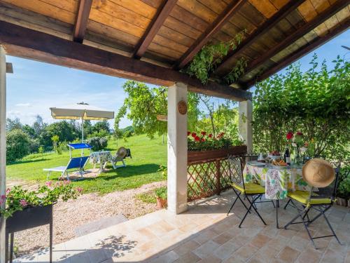 a patio with a table and chairs and an umbrella at Cozy Couple s Retreat in Acqualagna