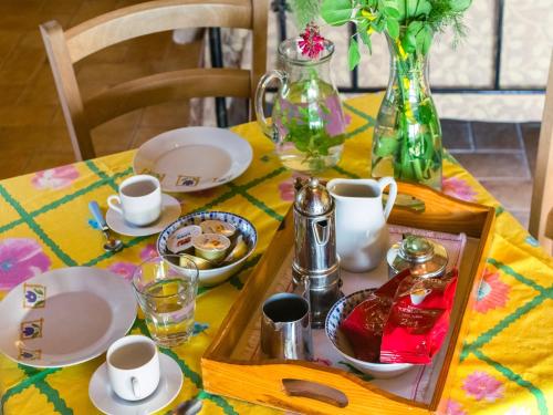 a table with a tray with dishes and a vase at Cozy Couple s Retreat in Acqualagna