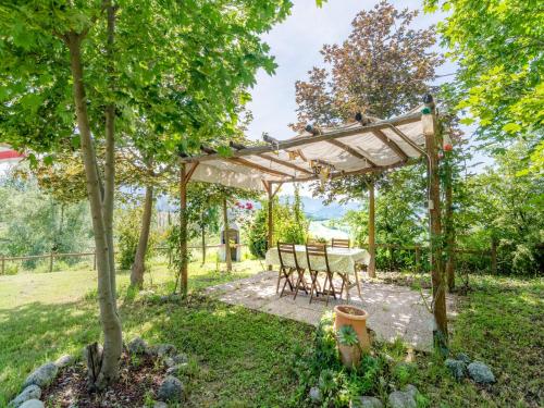 a table and chairs under a pergola in a garden at Cozy Couple s Retreat in Acqualagna