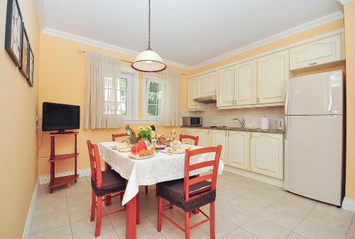 a kitchen with a table with chairs and a white refrigerator at Apartment Iva in Omiš