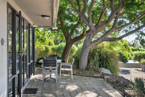 a patio with two chairs and a table and a tree at Petra Olive 1 in Yallingup