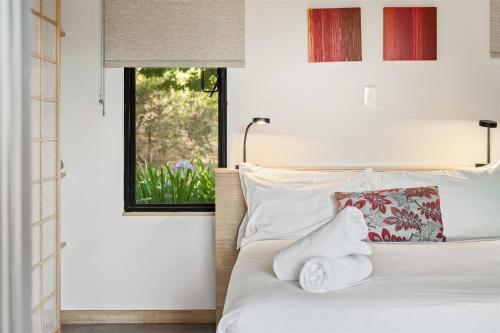 a bedroom with a white bed with towels on it at Petra Olive 1 in Yallingup