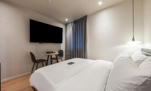 a hotel room with a bed and a flat screen tv at Pohang Mansion 6 Hotel in Pohang
