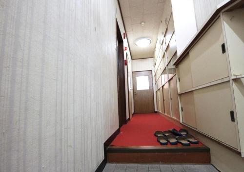 a hallway with a row of shoes on a red floor at Hokuriku Saikawa Building No,2 Building 3 Floor - Vacation STAY 17642 in Kanazawa