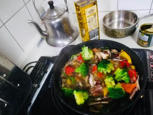 a pan of food on a stove with broccoli at 8-17 Nomura Motomachi - House / Vacation STAY 1893 in Hirakata
