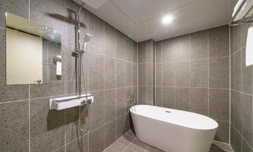 a bathroom with a sink and a bath tub at Pohang Mansion 6 Hotel in Pohang