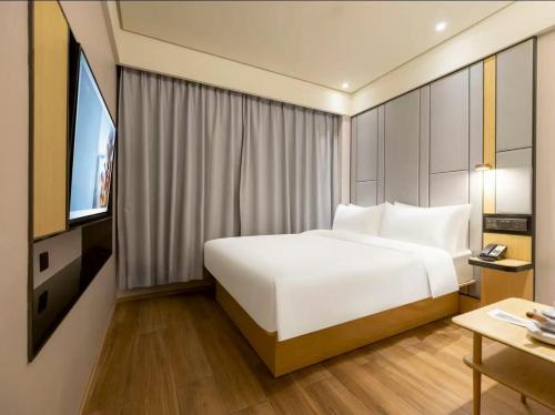 a hotel room with a bed and a television at 全季北京南站角门东地铁站酒店 in Beijing