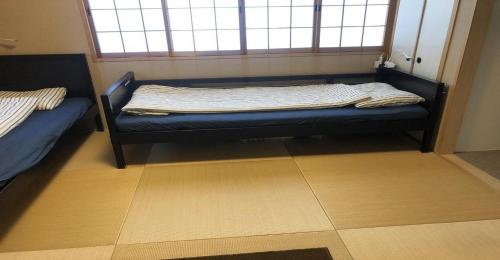 a bed sitting in a room with a window at 3-25-2 Higashiogu - Apartment / Vacation STAY 8348 in Tokyo