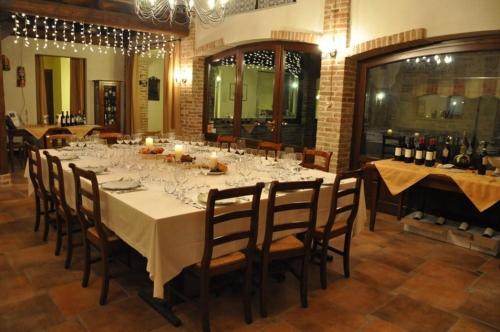 a dining room with a long table with wine glasses at Rosso Di Sera in Novello