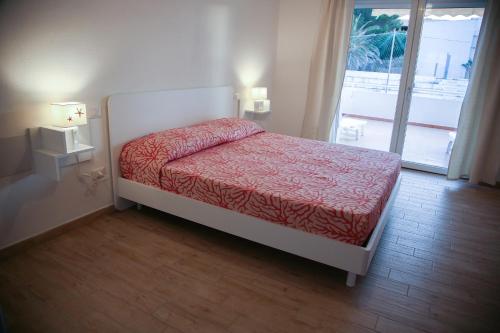 a small bed in a room with a window at B&B Le tre Spiagge in Calasetta