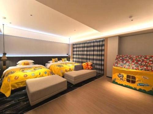 two beds in a room with yellow beds and a couch at Movie Star Hotel in Guangzhou