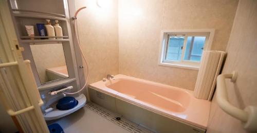 a bathroom with a tub and a sink and a mirror at Kumano - House / Vacation STAY 9764 in Kumano