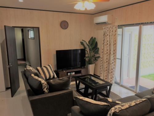 a living room with two couches and a tv at Nago - House / Vacation STAY 76289 in Nago