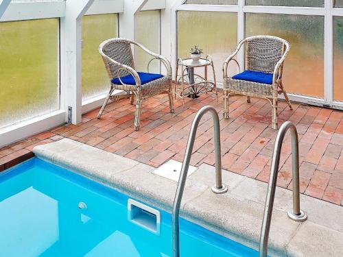 two chairs and a table next to a swimming pool at Luxury Retreat with Pool - By Traum Ferienwohnungen in Hvalpsund