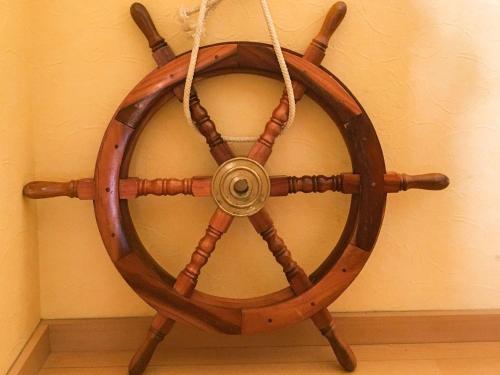 a wooden wheel attached to a wall with a rope at Pension Marinetown Aratta Vacation STAY 13299 in Yonabaru