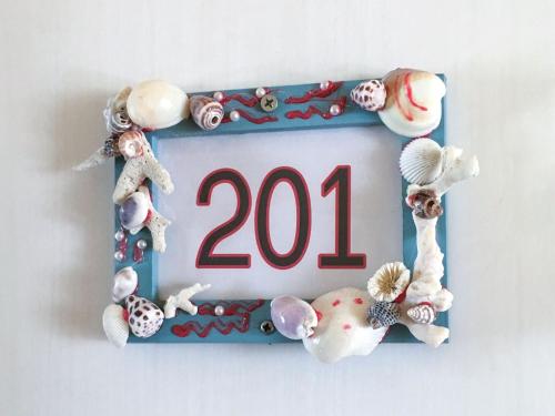a sign with seashells and a sign with the number at Pension Marinetown Aratta Vacation STAY 13299 in Yonabaru