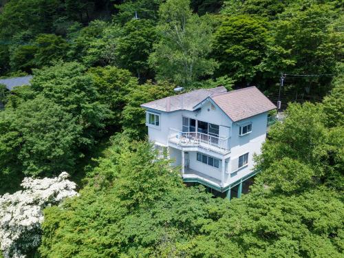 a large blue house in the middle of trees at Kanra-gun - House / Vacation STAY 2833 in Karuizawa