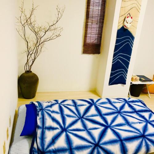 a bedroom with a blue blanket on a bed at Room 202 / Vacation STAY 13909 in Tokushima
