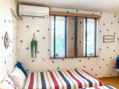 a bedroom with a bed and a window at Pension Marinetown Aratta Vacation STAY 13299 in Gaja