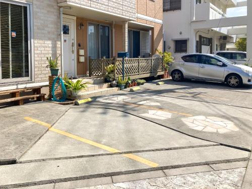 a car parked in a parking lot in front of a house at Pension Marinetown Aratta Vacation STAY 13299 in Gaja