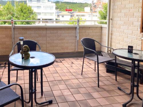 a patio with two tables and chairs on a balcony at Pension Marinetown Aratta Vacation STAY 13299 in Gaja