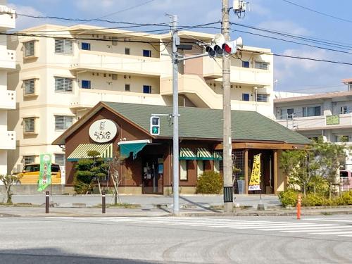 a building with a clock on it next to a street at Pension Marinetown Aratta Vacation STAY 13299 in Gaja
